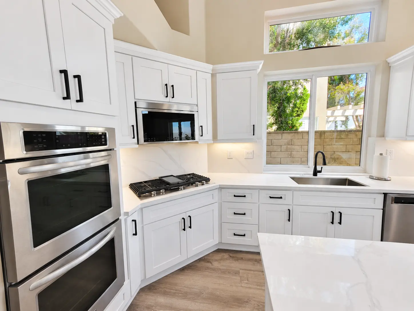 Two-tone kitchen with white cabinetry and natural wood accents